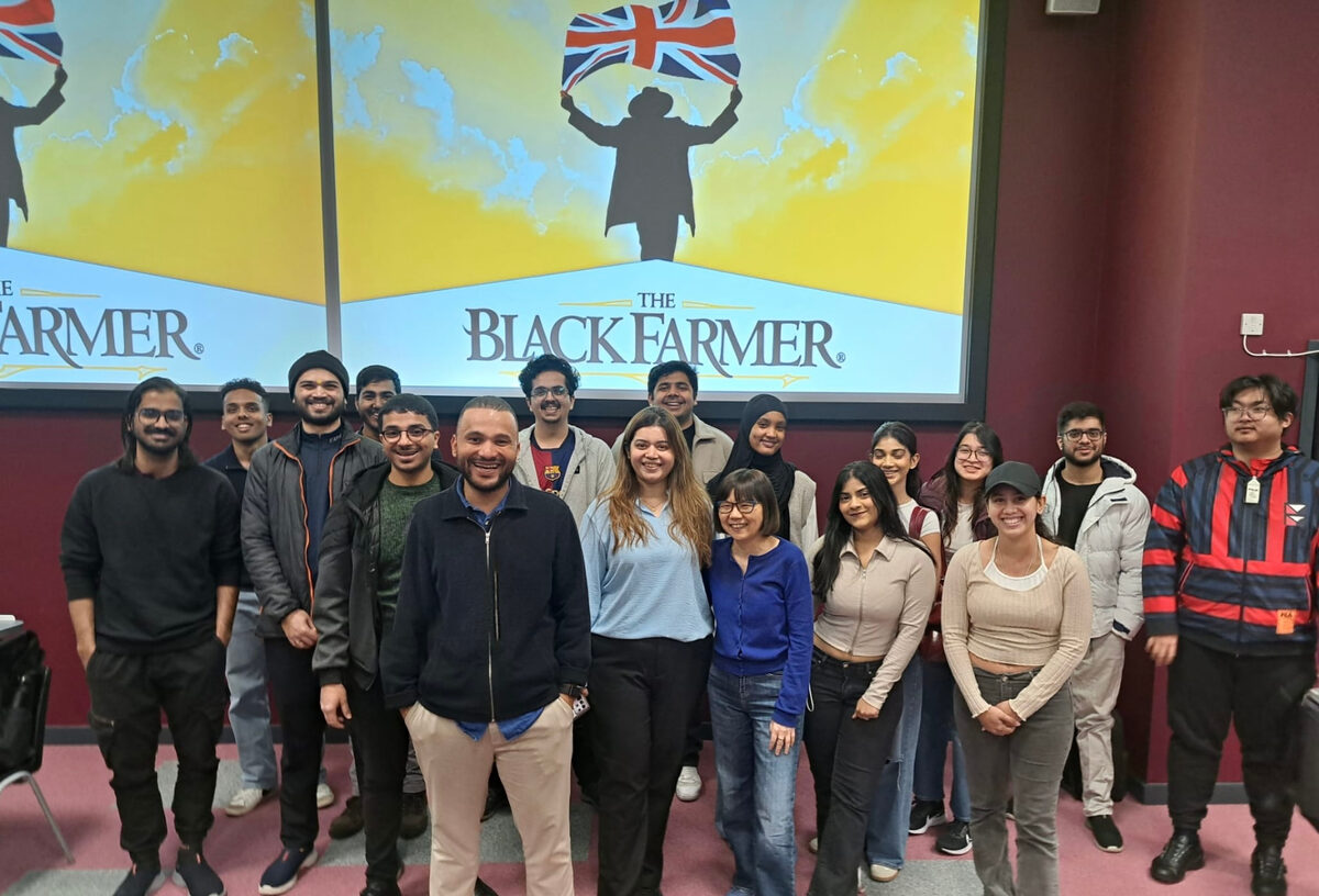 Alex with a workshop group in front of a Black Farmer screen