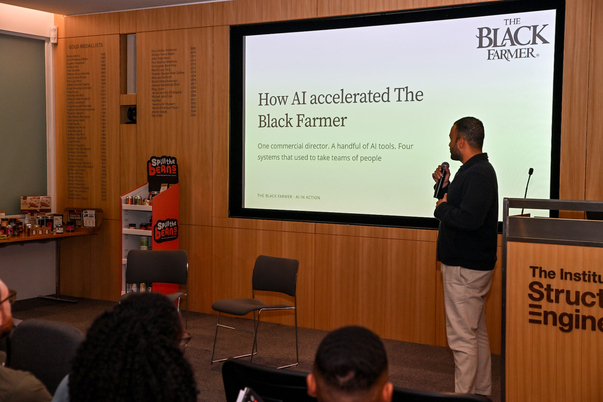Alex on stage presenting How AI accelerated The Black Farmer